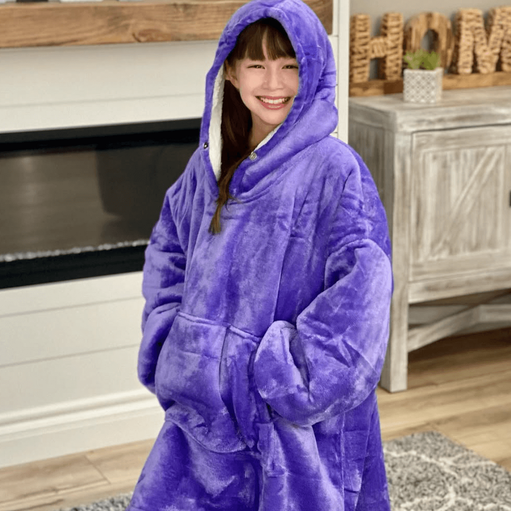 A little girl wearing a Tirrinia hoodie, feeling very comfortable and happy